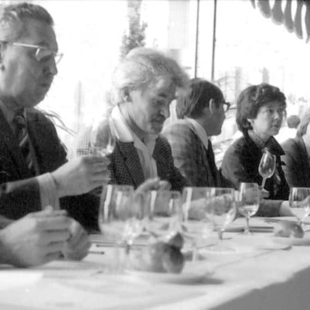 Group of people sitting at a table with wine glasses, black and white photo
