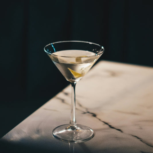 Cocktail in a martini glass on a dark surface