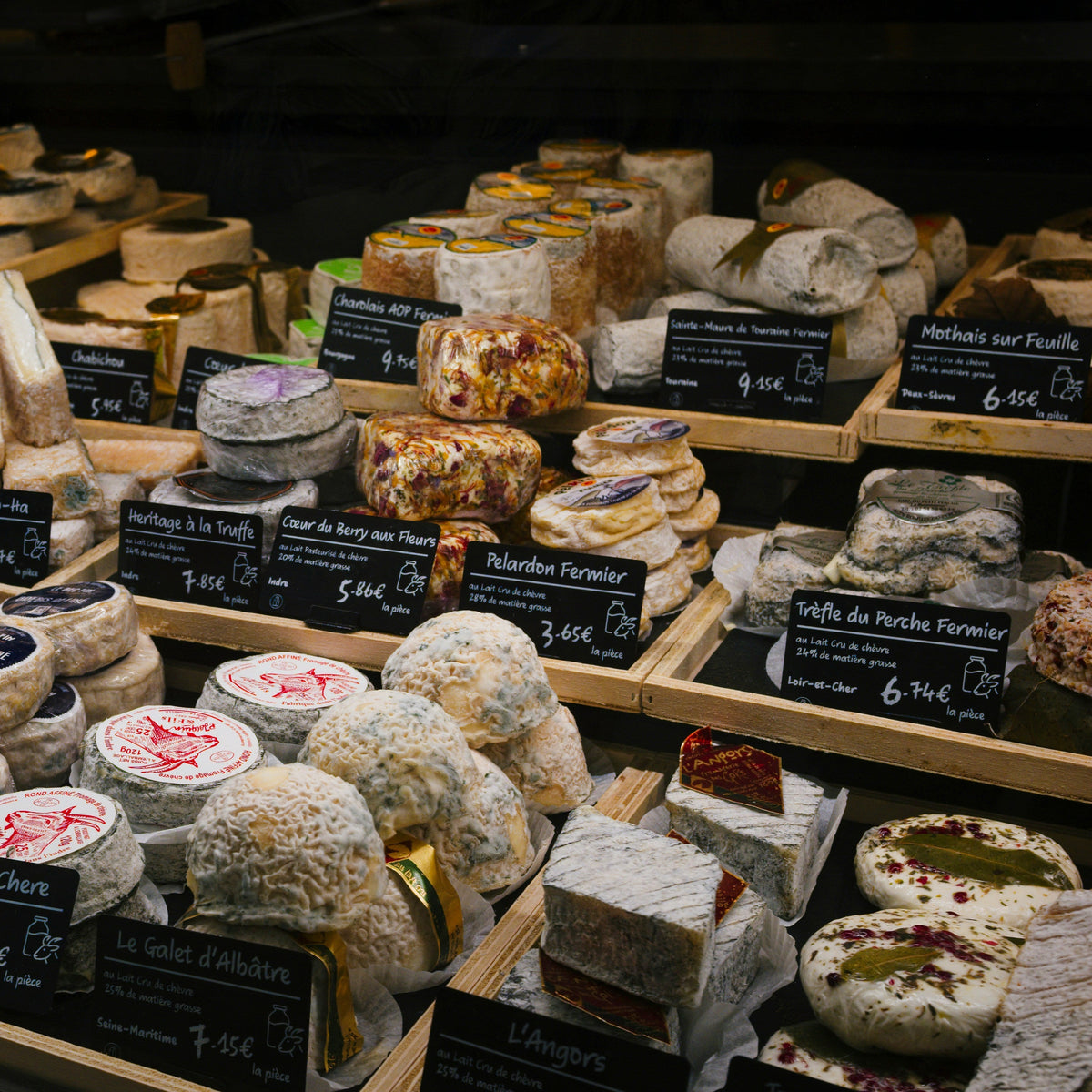 Piles of soft cheeses at a French cheese counter