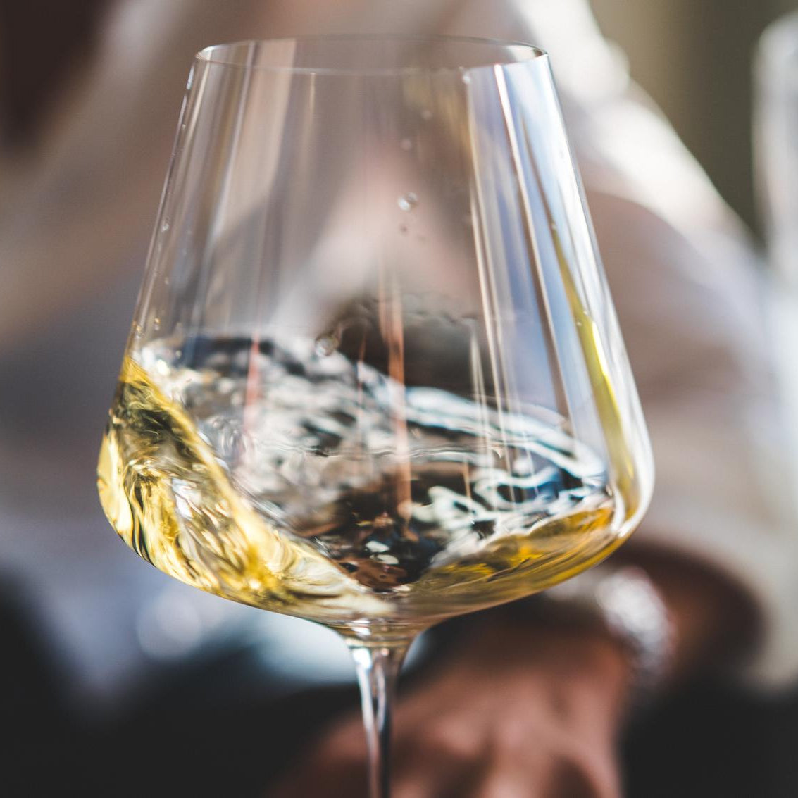 White wine being swirled in a stemmed wineglass